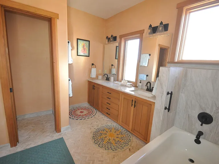 Large bathroom with access from hallway and bedroom.