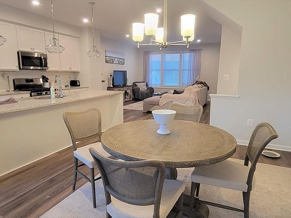 Open kitchen, dining, and living areas, with access to back deck as well as a powder room.