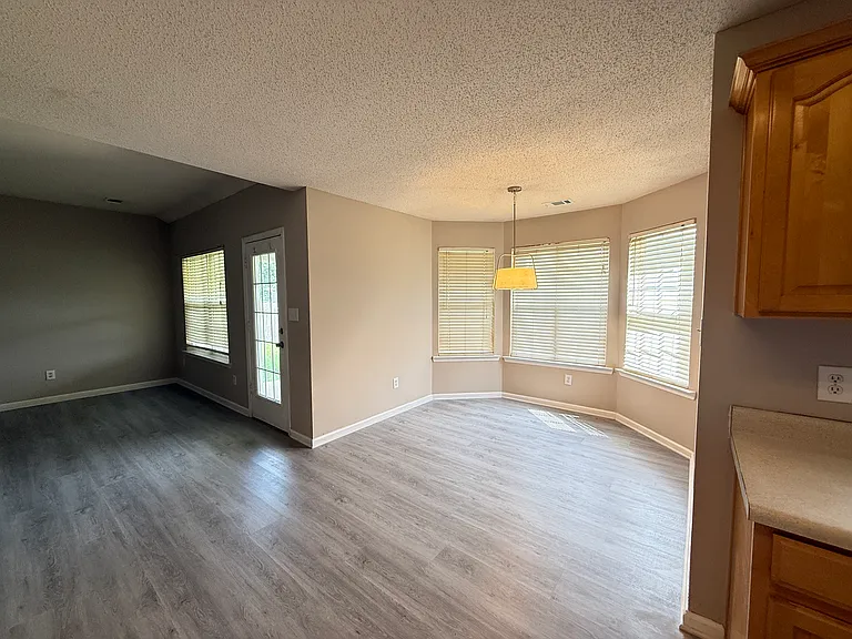 Bright dining space open to the living room, featuring patio doors that lead out to the backyard.
