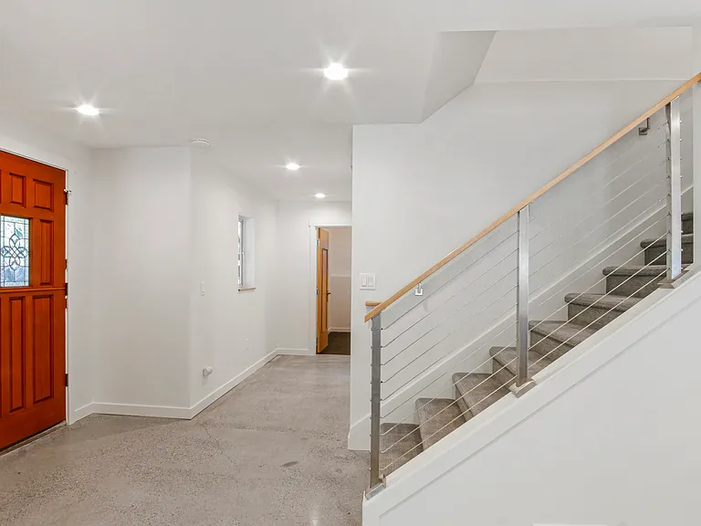 Front door with view down hall toward bedroom and upstairs