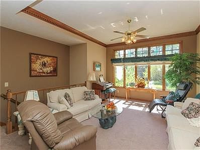 Great Room with Trayed Ceiling, Carpet, Ceiling Light/Fan and Wall of Windows.