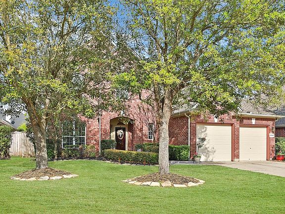 Mature trees and rock lined flower beds.