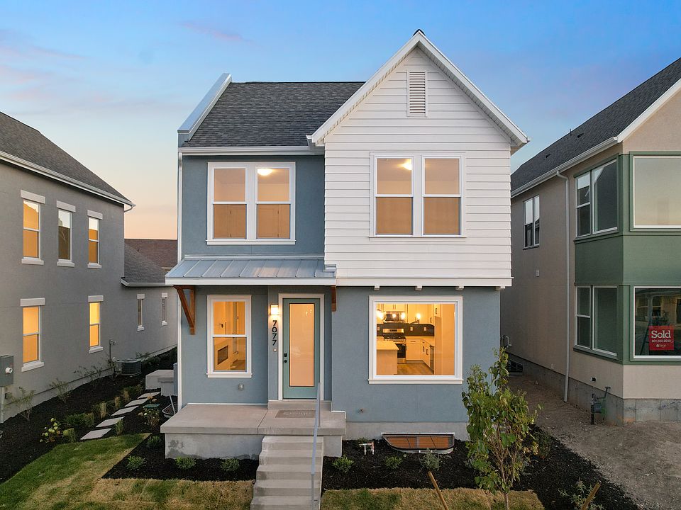 A modern two-story blue and white house from the Contempo Collection with large windows, a small fro