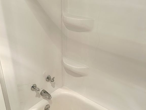 Full bathtub with recently added tub surround.