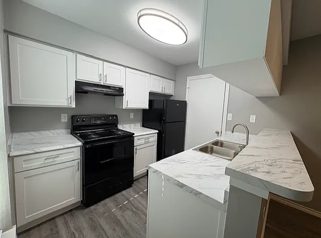 Updated apartment kitchen with modern appliances and cabinet storage