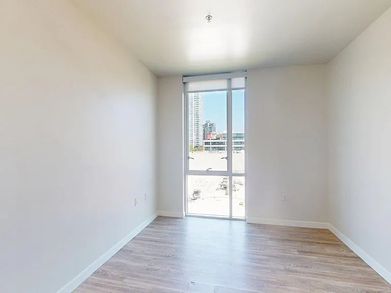Spacious apartment Bedroom with Wood-Style Flooring.