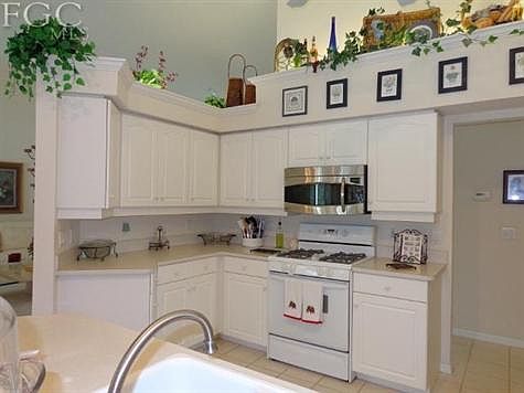 Kitchen w/gas range & plant shelving.