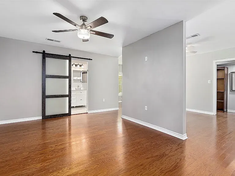 Master Bedroom with barn style door to bathroom. Room split with private Master Den