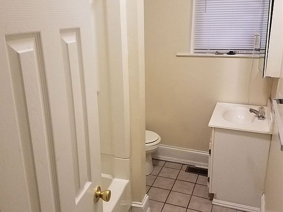Bathroom. Tub/shower, toilet and sink with medicine cabinet.