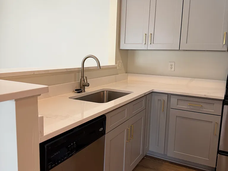 The kitchen has been upgraded with quartz countertops and new shaker style cabinets.