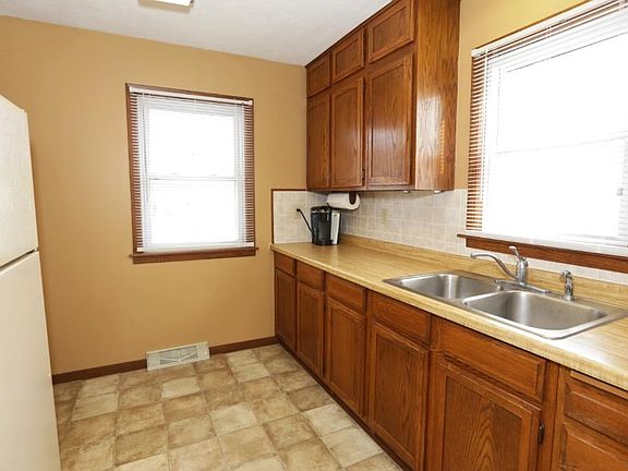 The kitchen overlooks the back yard at left and has a window over the sink at right.