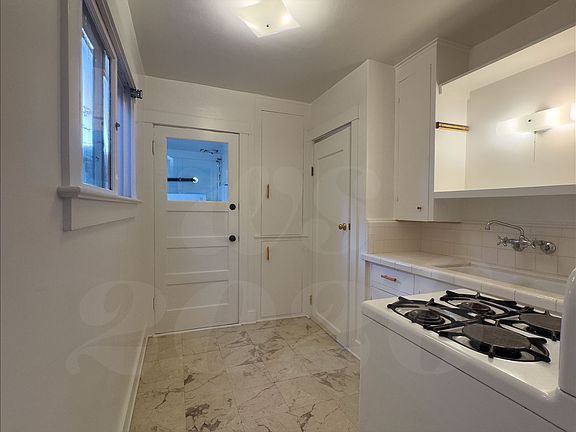 Kitchen, looking west to the laundry and bedroom.