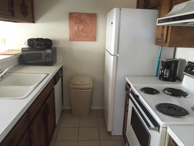 Galley Kitchen fully furnished with pans, plates and utensils