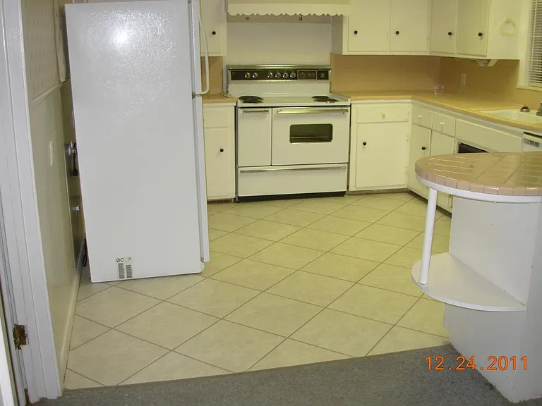 Kitchen with Ceramic Tile Counters and Vinyl Tile Flooring