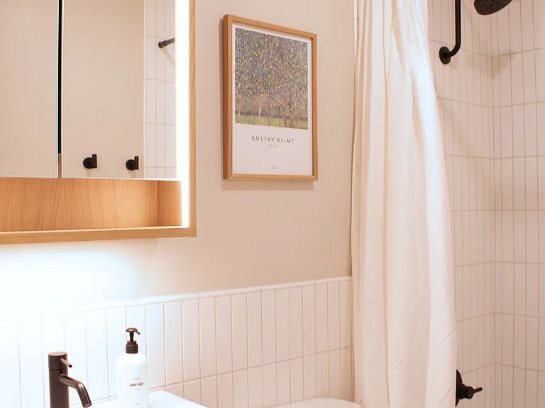 Full bathroom with shower/tub combo and modern finishes.