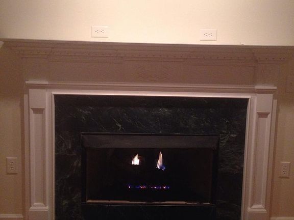 Gas Fireplace with White Mantel and Dark Green Marble Highli