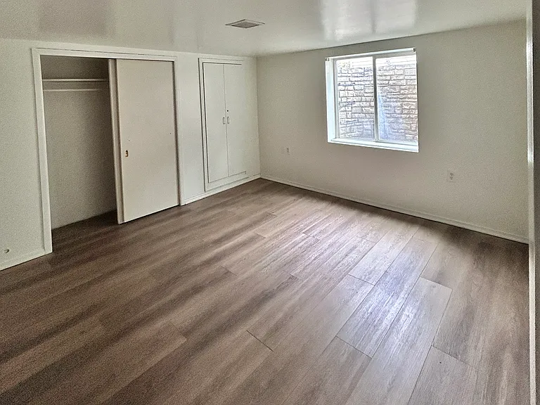 basement bedroom with new LVP flooring and egress window