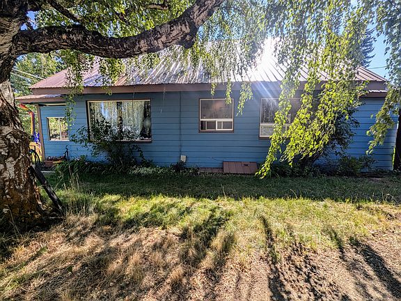 Side Yard. Large gravel parking area with side access gate and locking mailbox.