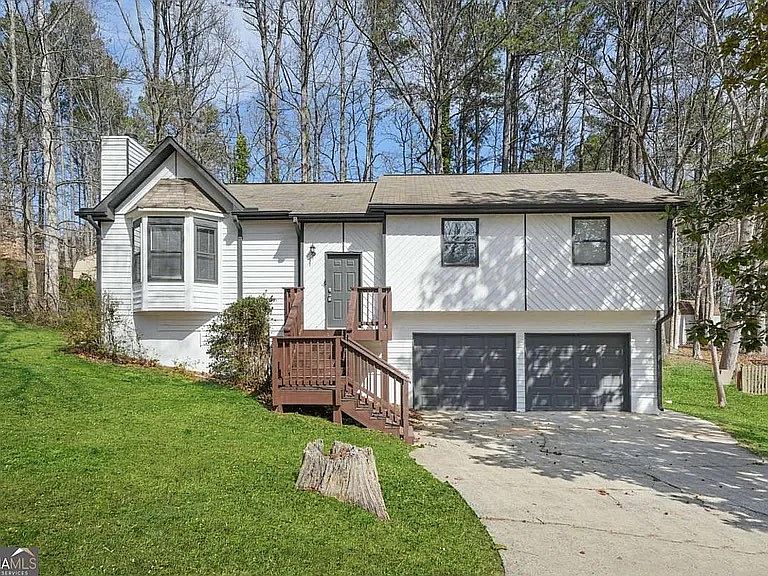 Front view of home with new landscaping being installed. Home has been freshly repainted. Steps to front door are brand new and stained.