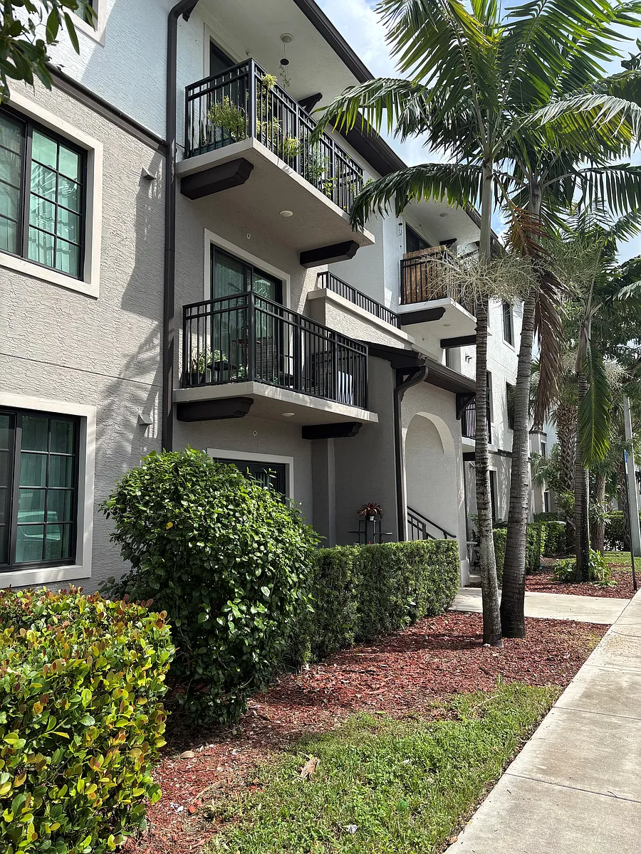 Private balcony with serene views and lush landscaping. Perfect for relaxing outdoors. - Redland Crossings