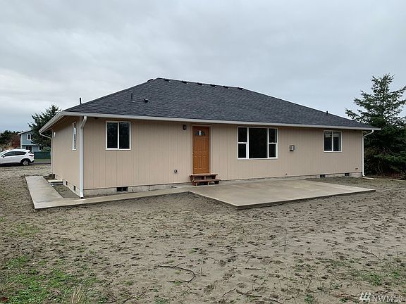 Back side of home showing wrap around sidewalk and large patio for you enjoyment!
