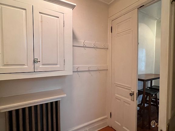 Apartment entryway with storage and French doors to kitchen area