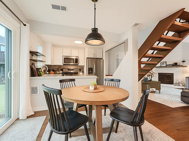 Enjoy this inviting space, nestled between a sleek kitchen and a stylish living room with a fireplace. It's a cozy, connected atmosphere perfect for gatherings.