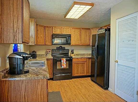 Exterior Front. Oak Cabinets, New Counters, & Black Appliances.