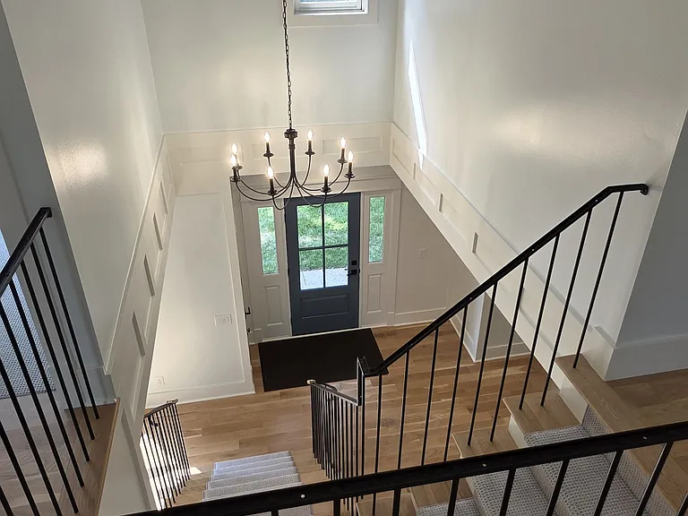 View from upper hallway of front door and chandelier.
