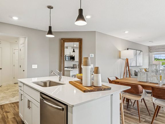 The center island overlooks the dining room and Great Room in an open design connecting shared living spaces