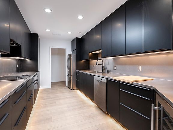 Remolded kitchen with new cabinets, stainless steel countertops, and wine refrigerator.