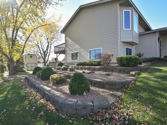 Side yard landscaping with retaining walls, shrubs and rock.