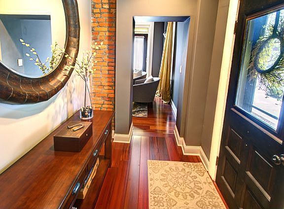 The entry boasts natural wood floors, exposed brick and wood trim.