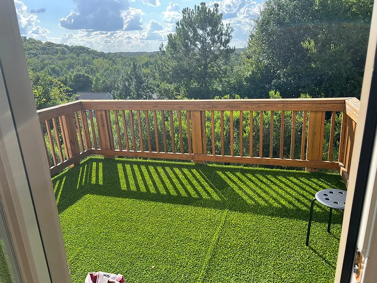 Private balcony/deck with durable flooring and wooded viewsideal for relaxing outdoors or enjoying morning coffee.