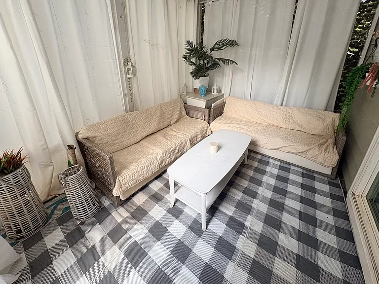 Private covered outdoor retreat designed for relaxing mornings, evening conversations, and year-round indoor-outdoor living with cozy lounge seating and a peaceful atmosphere.
