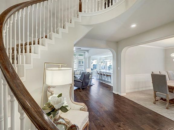 Enter the home and you are greeted by an grand, sweeping staircase and wood floors.