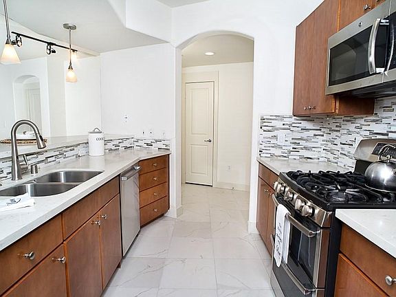 Spacious kitchen with quartz countertop, backsplash and breakfast bar