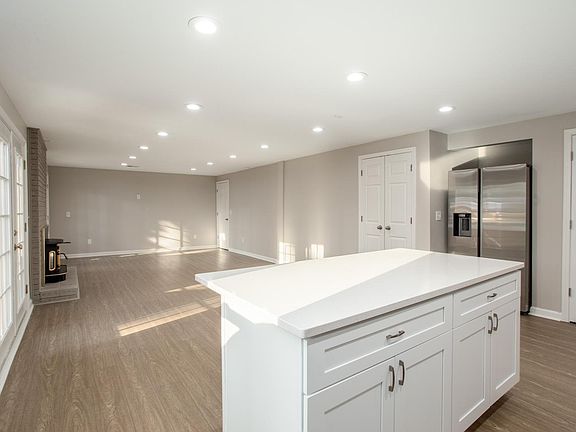 View of great room area from the kitchen. Doors are pantry, refrigerator, and coat closet. Door in corner is not used.