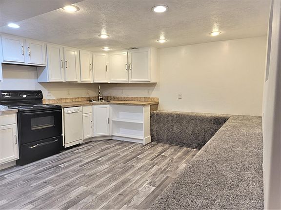 Kitchen has newly refinished cabinet's, new paint, new luxury vinyl flooring, custom tile countertops, and custom overflow shelving. Includes refrigerator, electric stove, dishwasher and microwave. It also includes built in carpeted seating. One window is