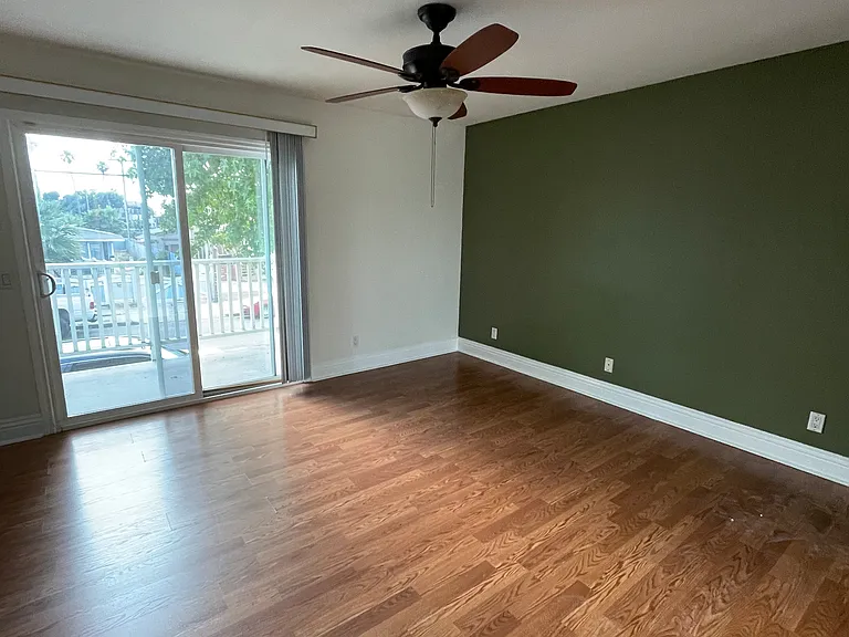 Primary bedroom with two closet areas and sliding door to balcony