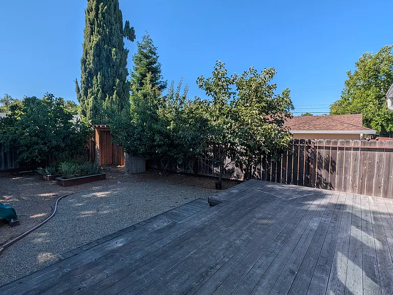 Large deck in the back, is perfect for hosting and a BBQ. Complete with a garden full of trees.