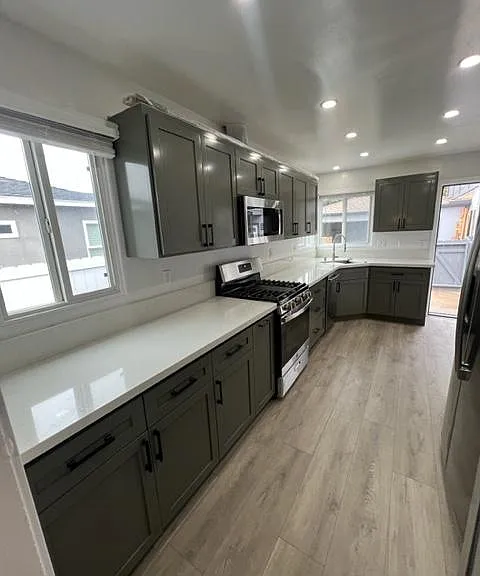 Lots of windows for natural light by day and contemporary lights by night in oversized kitchen