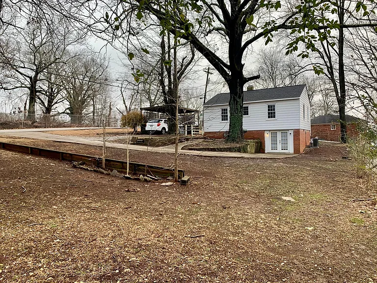 Back of the house. Showing plenty of yard and the entrance to the basement.
