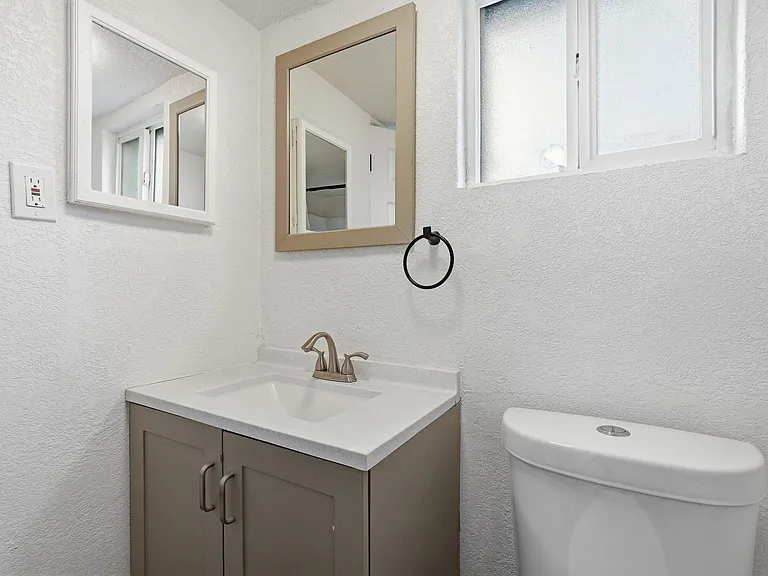 Built in vanity with ample cabinet space. Window to back lot opens and pulls light into bathroom.
