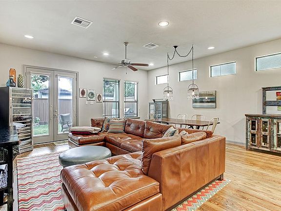 First floor living area with high ceilings and recessed lighting is bright, open, and spacious. French doors lead out to a covered patio and fenced yard.