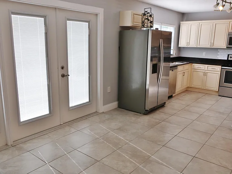 Kitchen and dining (partial view) showing blinds closed on French doors