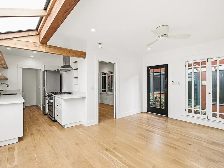 Living room with a view into the kitchen and bedroom door