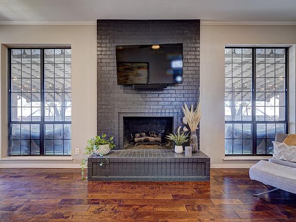 Living room features gas fireplace and large double windows