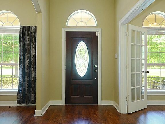  Guests enter from the Porch through a leaded glass door to this casually elegant Foyer with beautiful flooring, tasteful crown molding accents and views  that draw them inwards