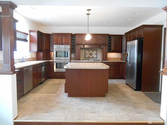 Amazing kitchen with custom cabinets, huge work area, propane range, and stainless appliances. Has a nice view of the private back yard.